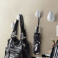 White resin water droplet wall hooks with black straps, shown with hanging bags