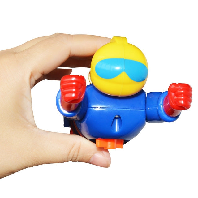 Blue and yellow clockwork diver bath toy held by hand, red flippers and helmet