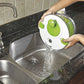 Salad spinner rinsing in sink with flowing water through the green drain basket