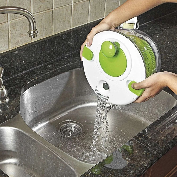 Salad spinner rinsing in sink with flowing water through the green drain basket