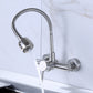 Wall-mounted kitchen faucet with flexible hose sprayer pouring water and twin control knobs