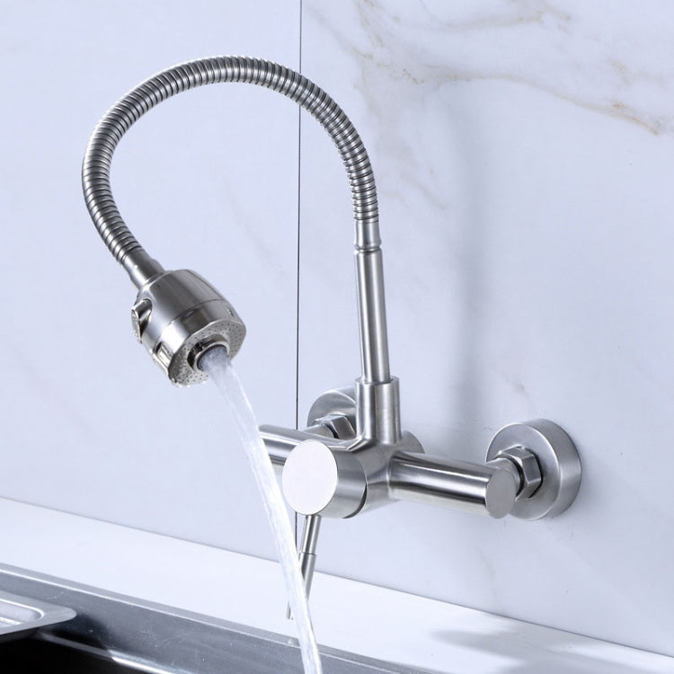 Wall-mounted kitchen faucet with flexible hose sprayer pouring water and twin control knobs