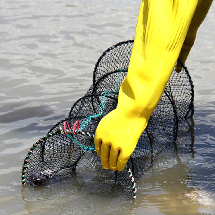 Fish trap net with dark mesh, lifted from water by a yellow-gloved hand