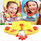 Pie face prank game toy with two character face panels, yellow base, and red lever with topping