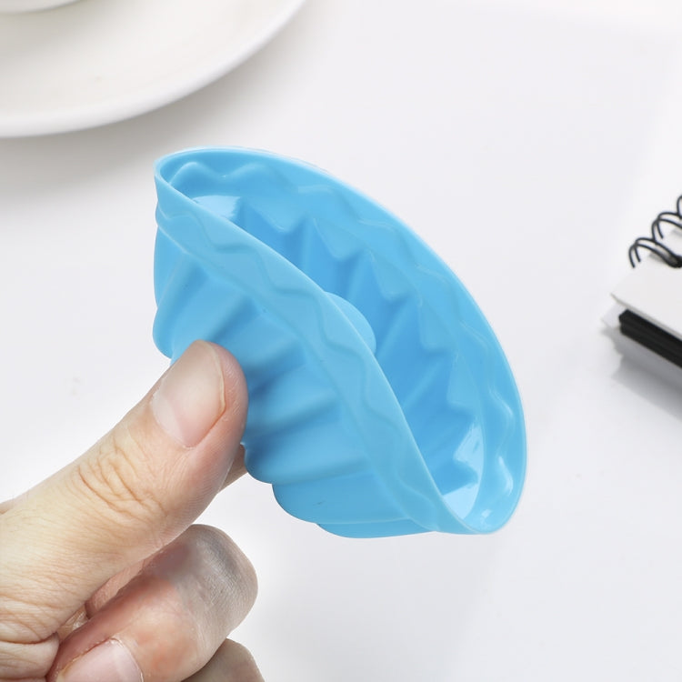Hand holding a blue silicone thread-shaped baking mold cup