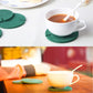 Tea cup on cactus coaster: green felt cactus pieces on cork pad with orange pot.