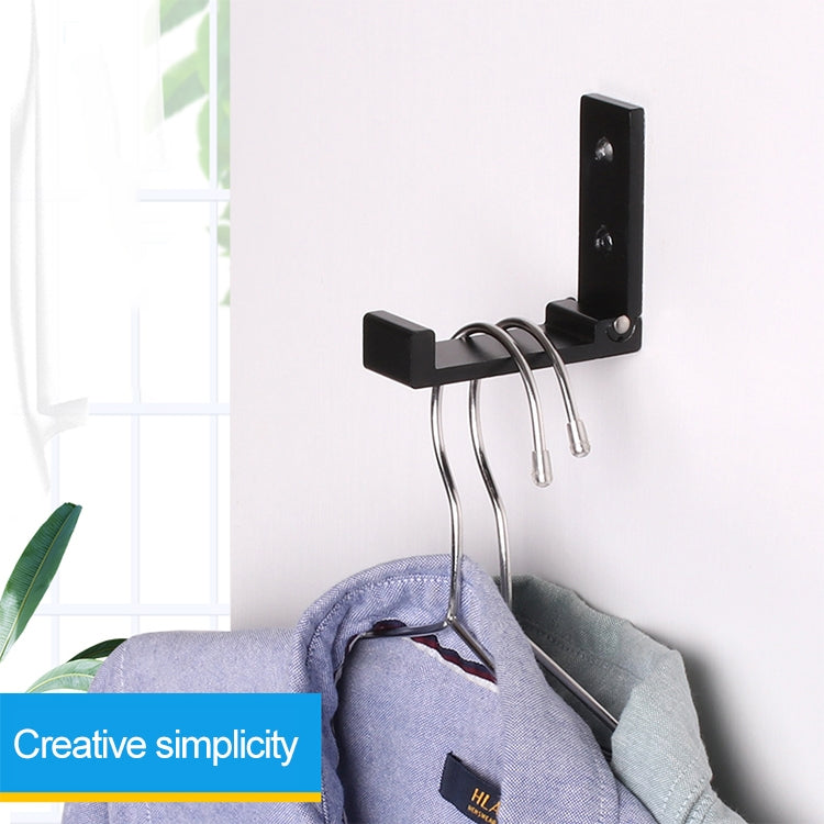 Black wall-mounted folding hook with metal rings for hanging coats or bags