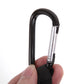 Hand holding black stroller hook with metal latch and curved carabiner