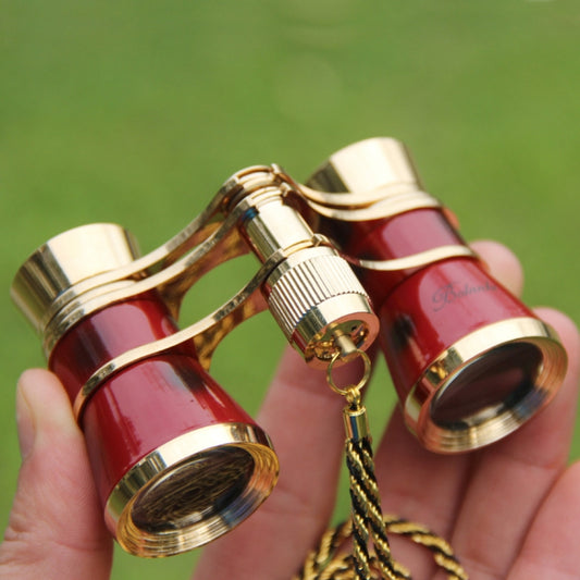 Red and gold-plated mini telescope set with chain, close-up of brass fittings