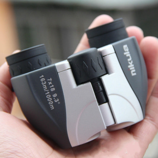 Nikula binoculars held in hand, showing side panels, black eyecups, and center hinge