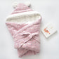 Pink baby holding blanket wrapped with hood and bow, white inner fabric lining