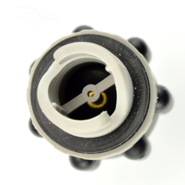 Top view of black inflatable valve adapter with white interior seal and brass pin