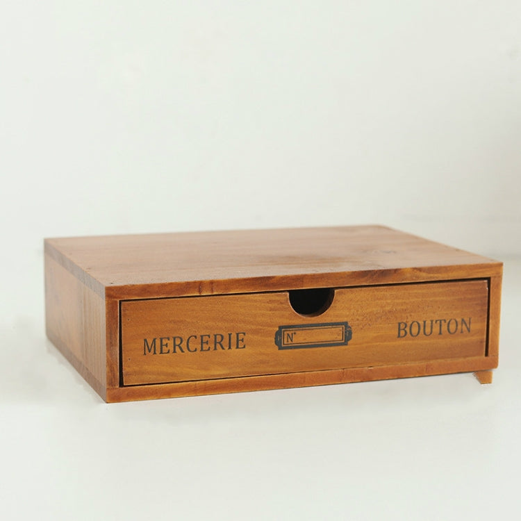 Wooden storage cabinet drawer with arched cutout handle and printed labels on front.