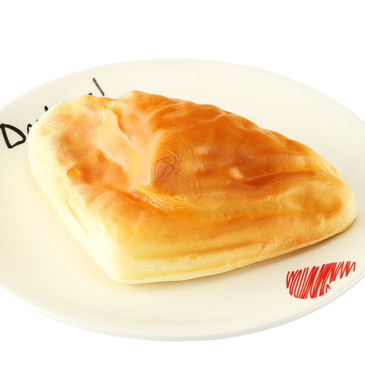 Cream and golden-brown PU bread model loaf on a white plate
