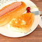 Two glossy golden-brown PU bread pieces with browned tops on a white plate