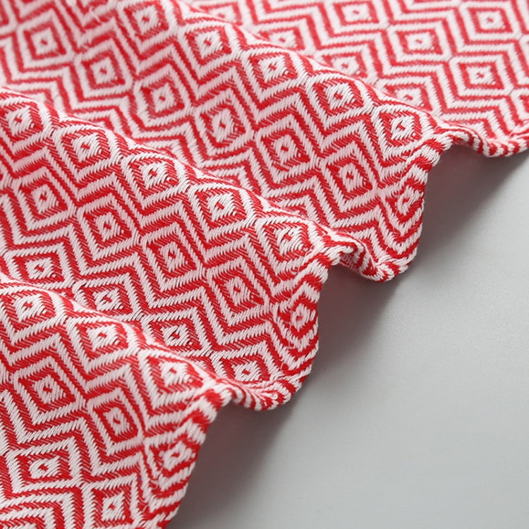 Corner view of red-and-white zigzag cotton bath towel with tassel edge