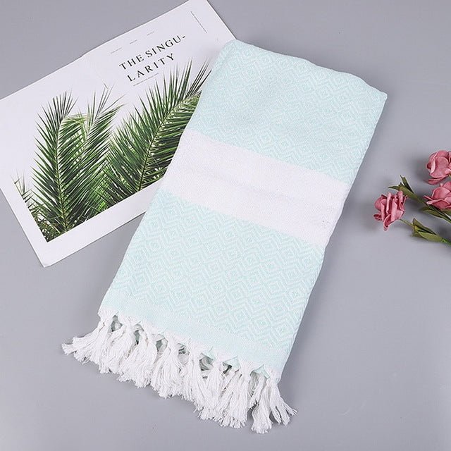 Cotton bath towel with light blue zigzag pattern, white band, and tassel fringe