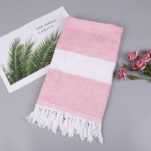 Cotton bath towel with pink zigzag pattern, white band, and tassel fringe