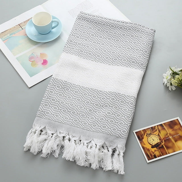 Cotton bath towel with gray zigzag pattern, white band, and tassel fringe