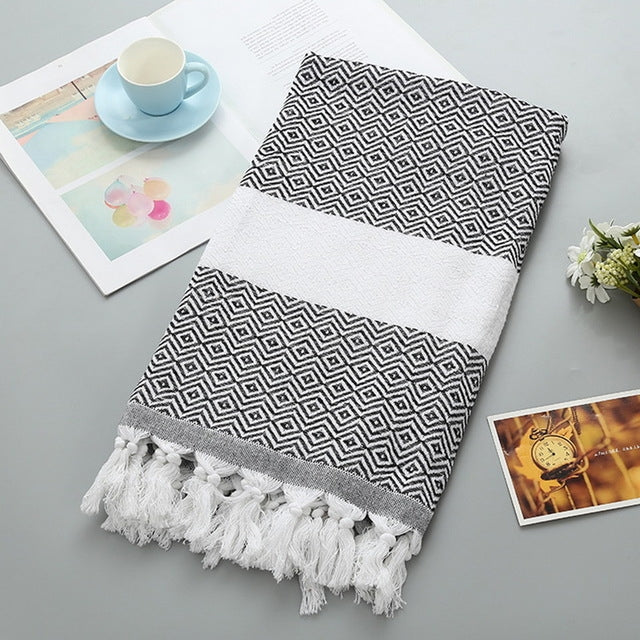 Cotton bath towel with black zigzag pattern, white band, and tassel fringe