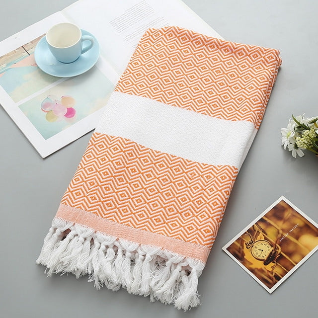 Cotton bath towel with orange zigzag pattern, white band, and tassel fringe