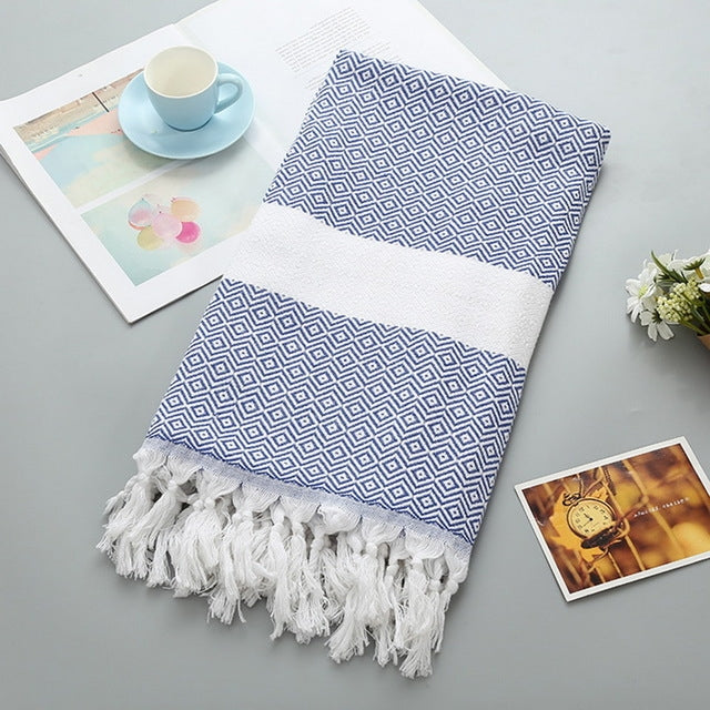 Cotton bath towel with navy blue zigzag pattern, white band, and tassel fringe