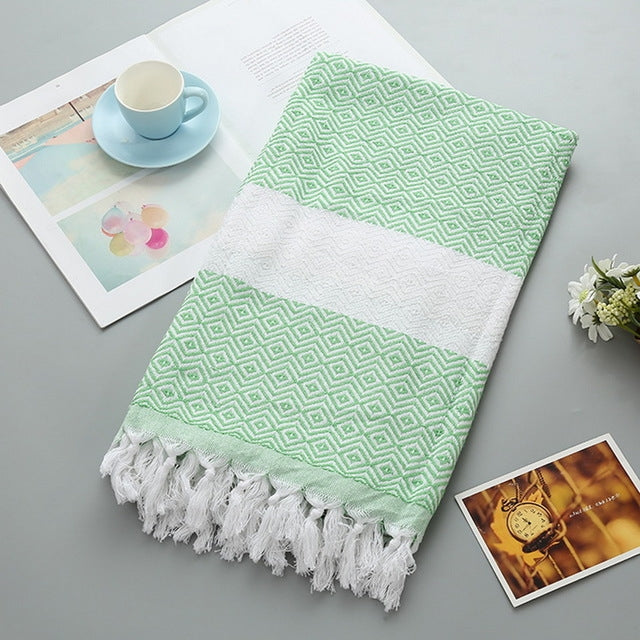 Cotton bath towel with green zigzag pattern, white band, and tassel fringe