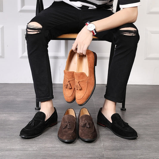 Men's suede tassel slip-on loafers in black and brown, side view on a person