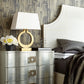Retro bedside lamp with oval ring base on dark dresser, beige shade