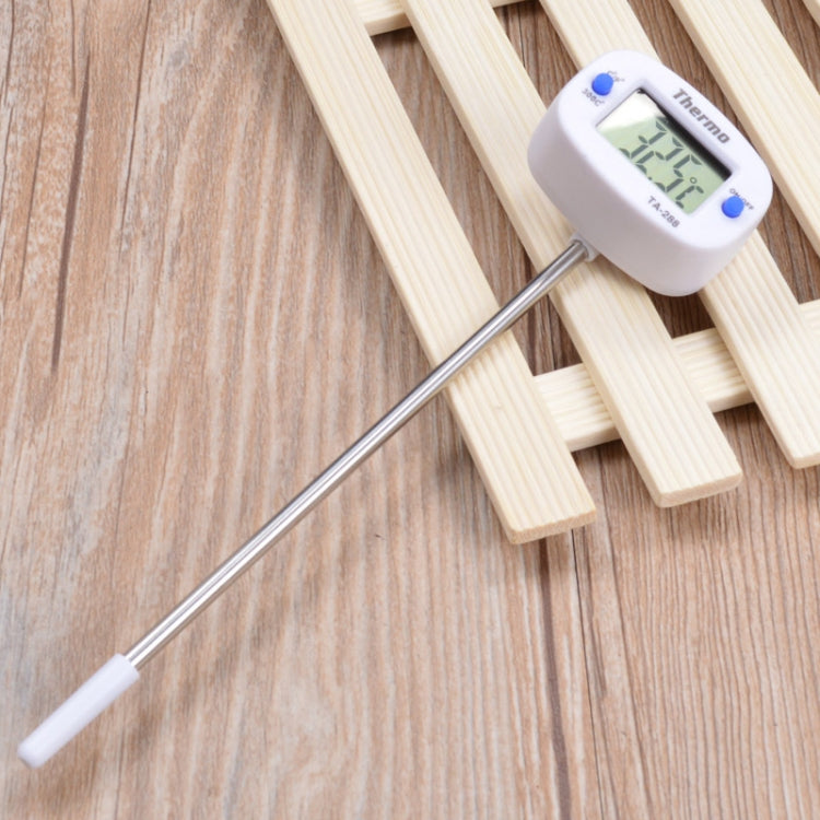 Food thermometer with plastic handle, metal probe, and LCD display on wooden slats