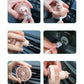 Pink mini car vent fan installed on dashboard vent, handheld adjustment