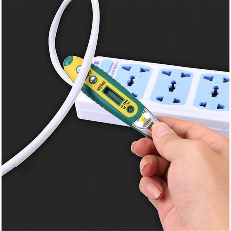 Voltage tester pen held near plug sockets on a power strip, LCD screen visible