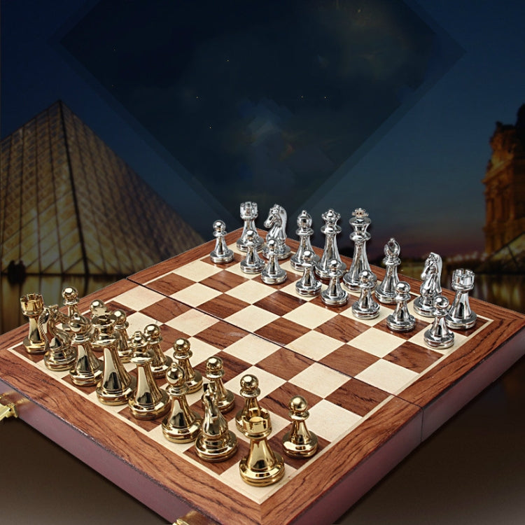 Wooden chess board with light and dark squares and silver and gold metal chess pieces