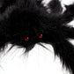Black plush spider decoration close-up with red glowing eyes
