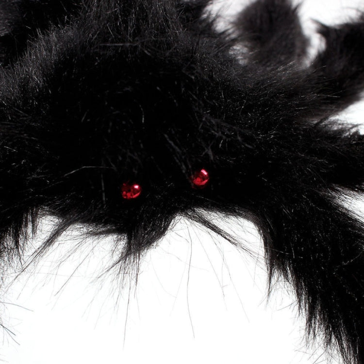 Black plush spider decoration close-up with red glowing eyes