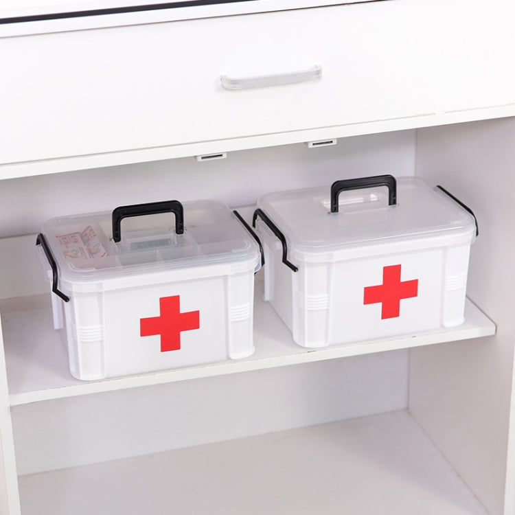 White plastic emergency medicine box with red cross stored on cabinet shelf