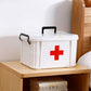 White plastic medical storage box with red cross and black carry handle on counter