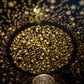Gold star projection pattern with dense sparkling points across a surface