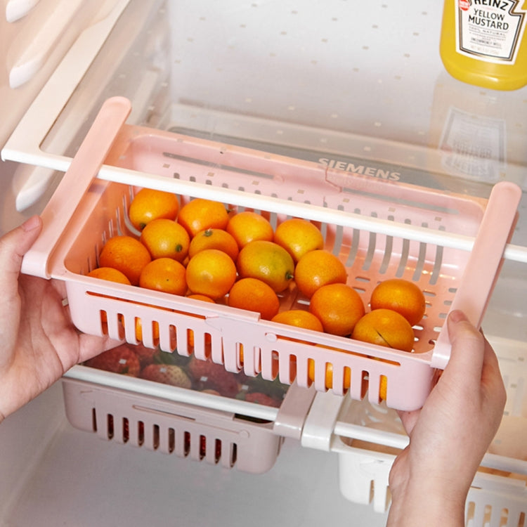 White refrigerator storage drawer shelf holding oranges in an open drawer