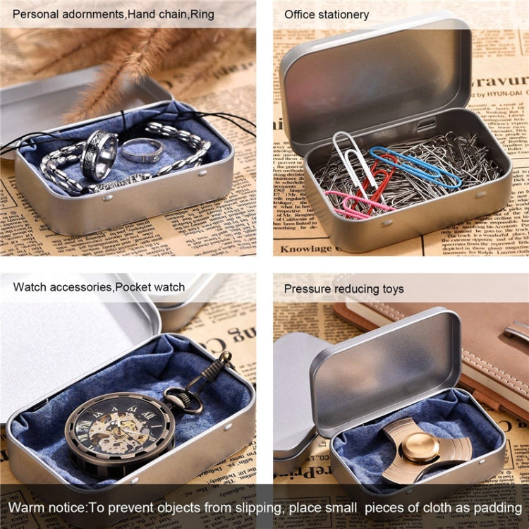 Silver metal storage box with lid open, holding small office accessories