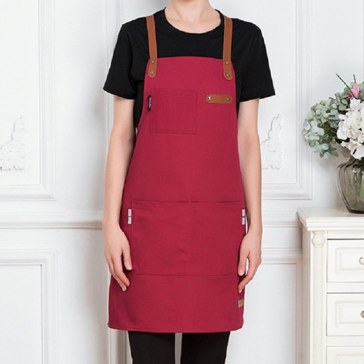 Red canvas apron with brown adjustable straps and front pocket, unisex workwear