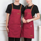 Pair of red canvas aprons with brown straps, chest pocket and waist patch pockets