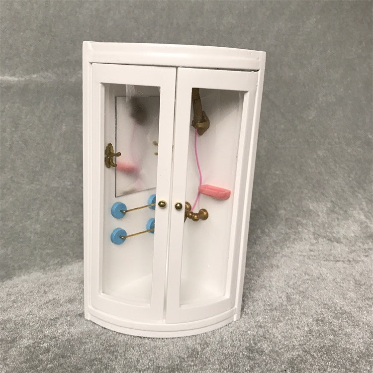 White dollhouse bathroom cabinet with two doors, blue towel bars, and gold fixtures