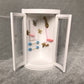 Open white dollhouse bathroom cabinet accessory with gold faucet, pink tub, and blue bars