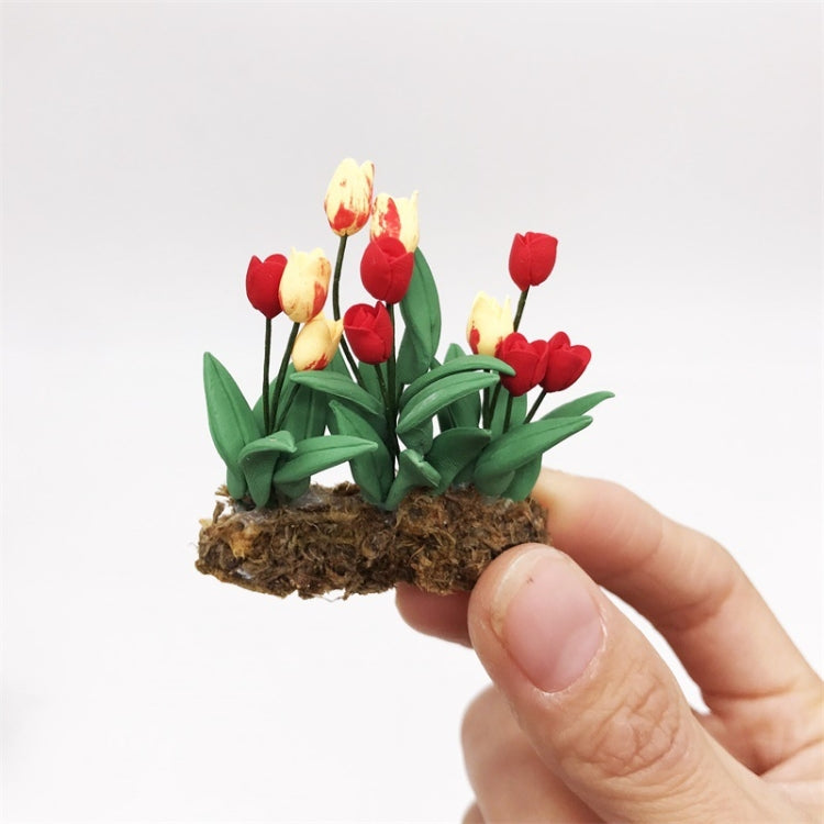 Mini tulip flower model held by hand, red and yellow tulips with green leaves