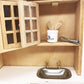 Mini dollhouse kitchen utensil set on open shelf: crock, wooden spatulas, whisk