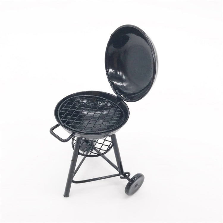 Mini round outdoor oven toy with closed lid and tripod legs, black metal finish