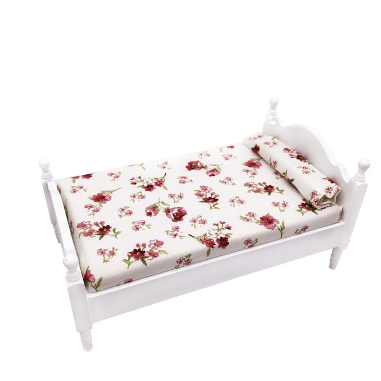 Miniature white single bed with floral bedding set, view from the side