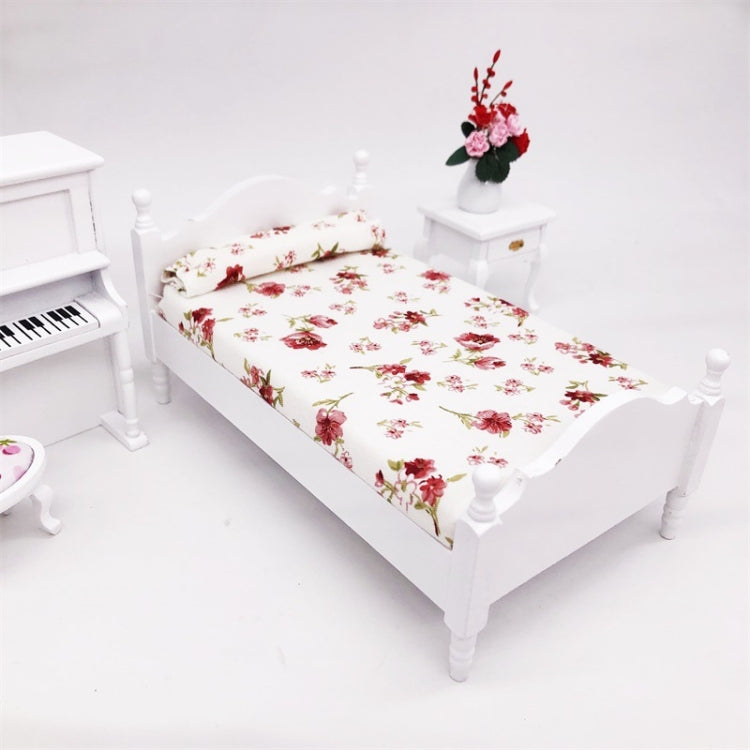 Miniature white single bed with floral mattress and rolled pillow, bedroom corner