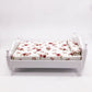 Miniature white single bed with floral mattress and pillow, front view